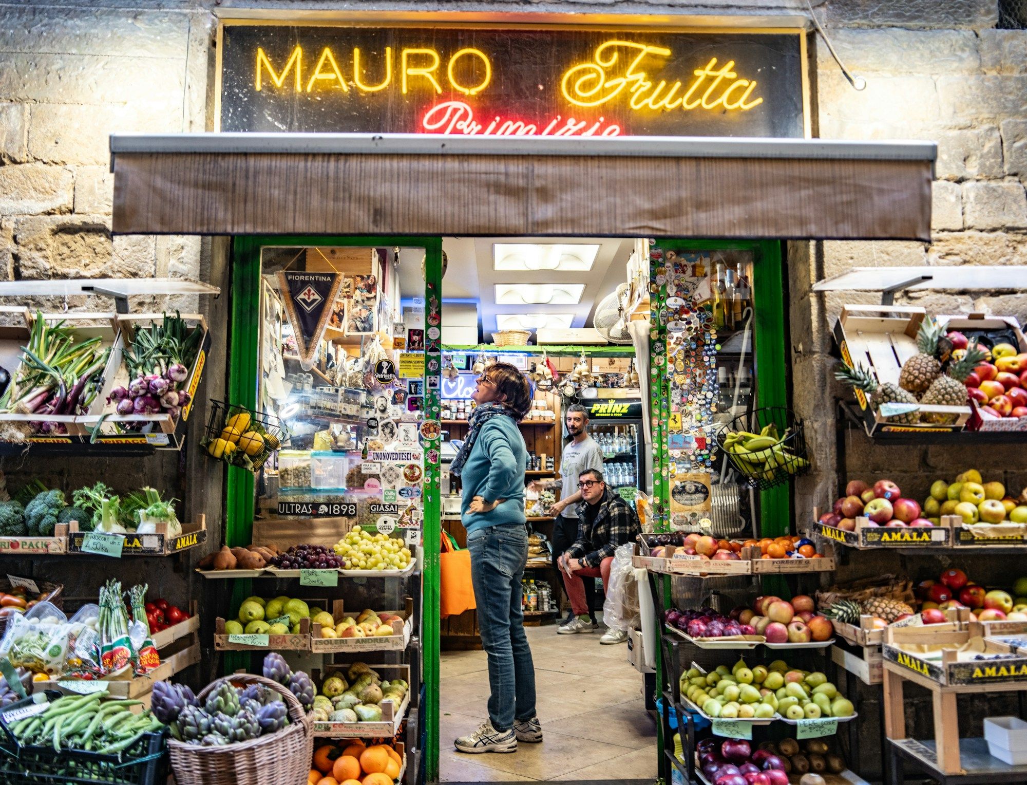 A fruit and vegetable shop with crates of produce on the street